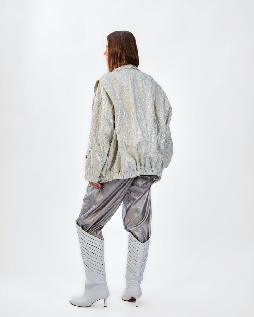 A soft champagne-beige textured jacket with a subtle luminous finish